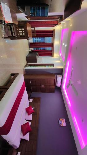 a room with a bed and a tub with pink lights at Coorg ASHOK PALACE in Madikeri