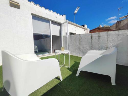 two white chairs and a table on a balcony at Mazi Apartments Penthouse in Badalona