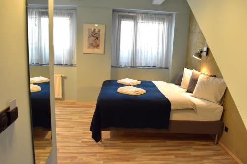 ein Schlafzimmer mit einem Bett mit einer blauen Decke in der Unterkunft Residence Řipská 26 in Prag