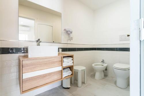 a white bathroom with a sink and a toilet at Hotel & Spa Relais Freedom Club in Massa Lubrense