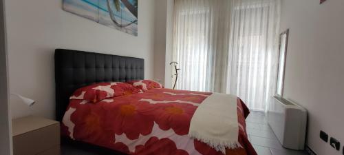 a bedroom with a red and white bed and a window at LF Luxury Homes Milano in Milan