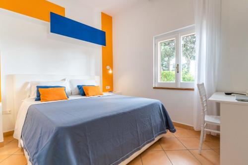 a bedroom with a bed with blue sheets and orange pillows at Hotel & Spa Relais Freedom Club in Massa Lubrense