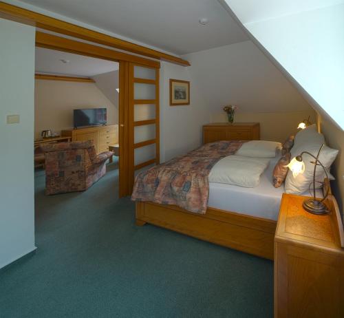 a bedroom with a large bed and a staircase at Hotel Praha in Hřensko