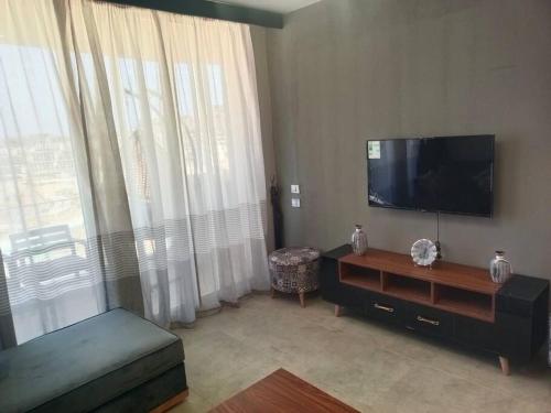 a living room with a flat screen tv and a couch at Lagoon View 2 Bedroom IL Monte Galala Ain Sokhna C2-CH28-2-1 in Ain Sokhna