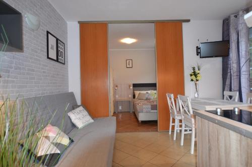 uma cozinha e sala de estar com um sofá e uma mesa em Apartamenty Poddąbie z ogródkiem em Poddabie