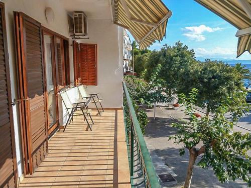 un balcón de una casa con mesa y sillas en Apartman Melis, en Podgora