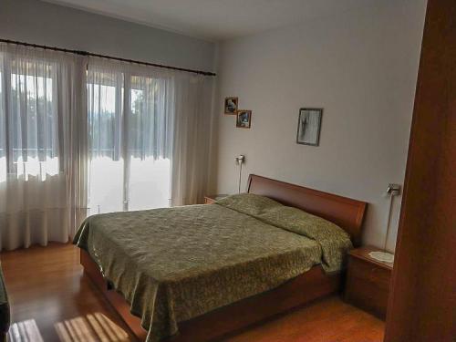 a bedroom with a bed and a large window at Apartman Melis in Podgora