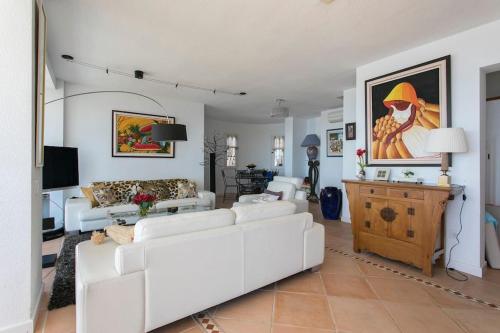 uma sala de estar com um sofá branco e uma mesa em VILLA ALTEA HILLS, vue mer, piscine chauffée, WIFI em Alicante
