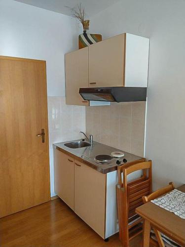 a small kitchen with a sink and a stove at Apartman Melis in Podgora