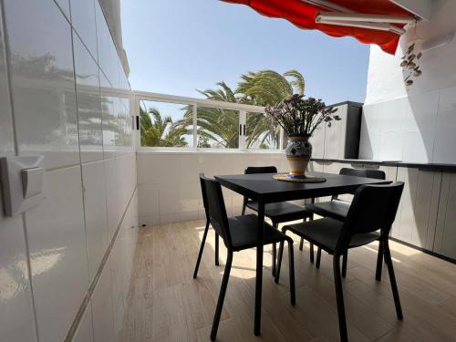 a black table and chairs in a kitchen with a window at Chaparral in Costa Del Silencio
