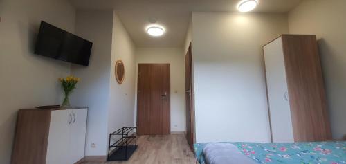 a bedroom with a bed and a flat screen tv at Zajazd Stronie in Stronie Śląskie