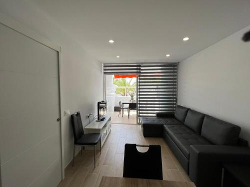 a living room with a black couch and a table at Chaparral in Costa Del Silencio