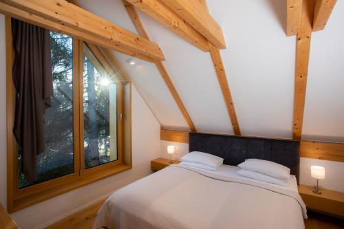 a bedroom with a bed and a large window at Ambient Resort Bled in Bled