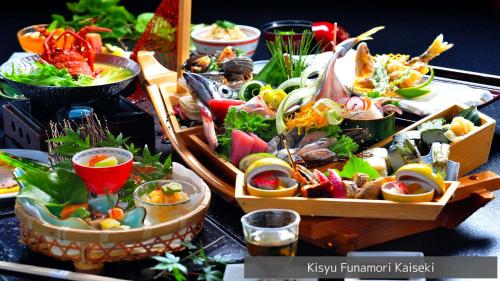 una mesa cubierta con diferentes tipos de alimentos en cestas en Hamachidorinoyu Kaisyu, en Shirahama