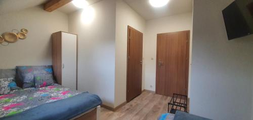a bedroom with a bed and a chair in it at Zajazd Stronie in Stronie Śląskie