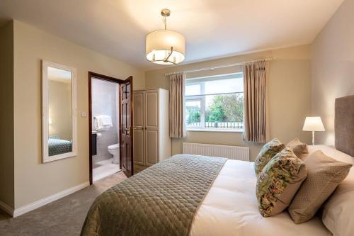 a bedroom with a large bed and a bathroom at Naughtons Villa in Killarney