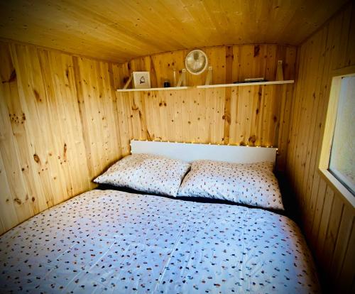 um quarto com uma cama num quarto de madeira em Maringotka Za Trnkou 