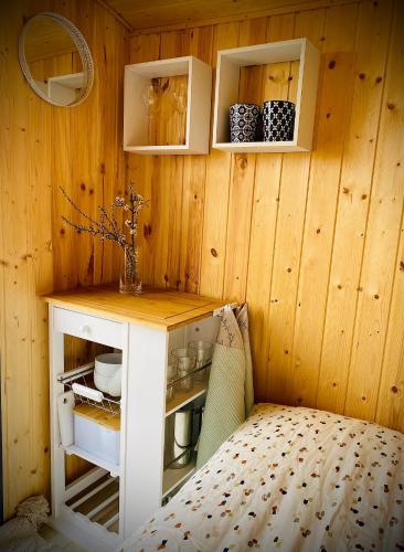 a room with a wooden wall with a counter and a table at Maringotka Za Trnkou in Točník