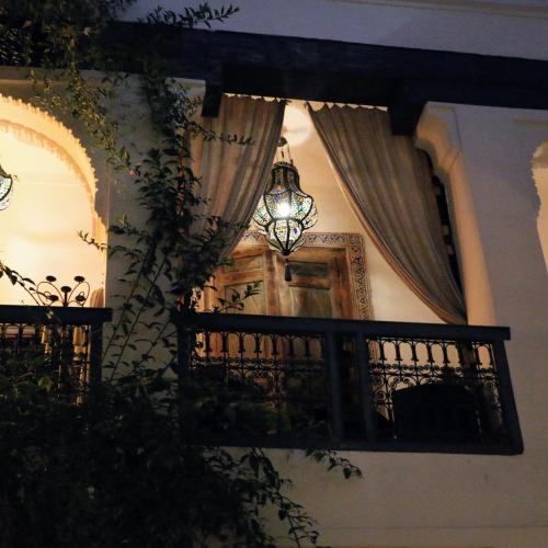 un balcone con un lampadario e una finestra con tende di Riad Dar Oulhoum a Marrakech