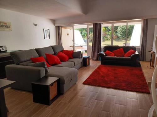 uma sala de estar com um sofá e almofadas vermelhas em Mouragolf 3 bedroom townhouse em Vilamoura
