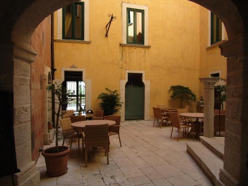 an outdoor patio with tables and chairs in a building at Antichi Feudi Dimora D'Epoca in Teggiano
