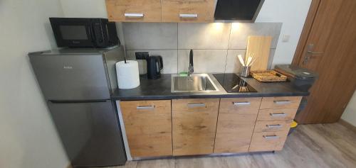 a small kitchen with a refrigerator and a sink at Zajazd Stronie in Stronie Śląskie