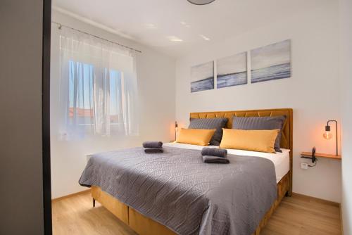 een slaapkamer met een groot bed met oranje kussens bij Apartment Sophia in Medulin