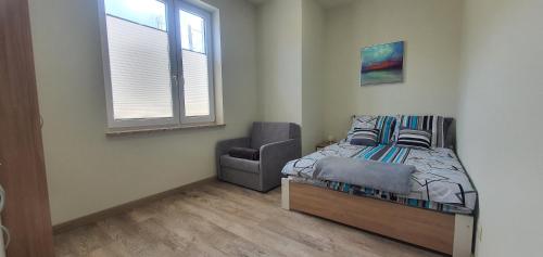 a bedroom with a bed and a chair in it at Zajazd Stronie in Stronie Śląskie