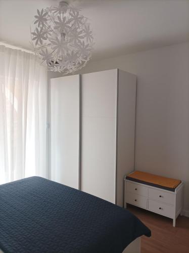 a bedroom with a blue bed and a chandelier at Neda Apartmani in Mali Lošinj