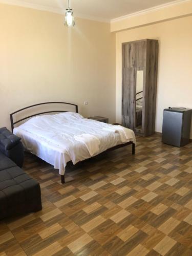 ein Schlafzimmer mit einem Bett und einem TV in der Unterkunft Nigatun Hotel in Yerevan