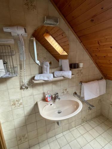Hotel Pension Balthasar في Müden: حمام مع حوض ومرآة