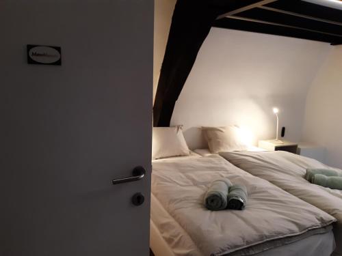 a bedroom with a large white bed with a wooden ceiling at Het Maelslot (Mechelen) in Mechelen