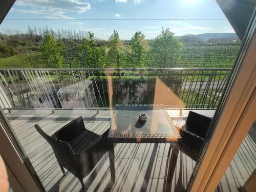 a glass table and chairs on a balcony with a view at Kikapcs apartman in Alsóörs