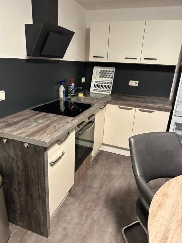 a kitchen with a stove top oven next to a table at Ferienwohnung an der Allee in Memmingen in Memmingen