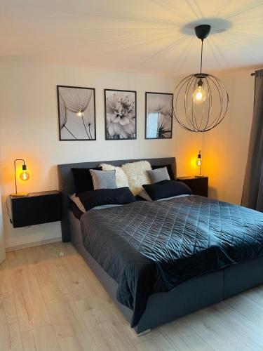 ヘルデッケにあるFerienwohnung am Hengsteyseeのベッドルーム1室(ベッド1台付)が備わります。壁に3枚の写真が飾られています。