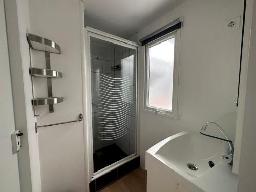 a white bathroom with a sink and a shower at Chalet 582 op Recreatiepark de Wielen in Sint Maarten