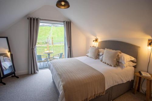 una camera con un grande letto e un balcone di Ty Carreg cottage, Bwlch, Brecon a Brecon