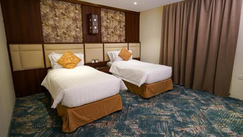 Habitación de hotel con 2 camas y cortinas en فندق جاردن فيو en Tabuk