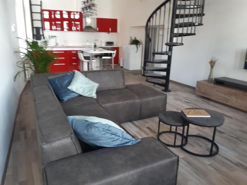 ein Wohnzimmer mit einem Sofa und einer Küche in der Unterkunft Het Maelslot (Mechelen) in Mechelen