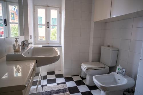 a white bathroom with a sink and a toilet at Embarcadero with New Powerful WiFi in Camogli