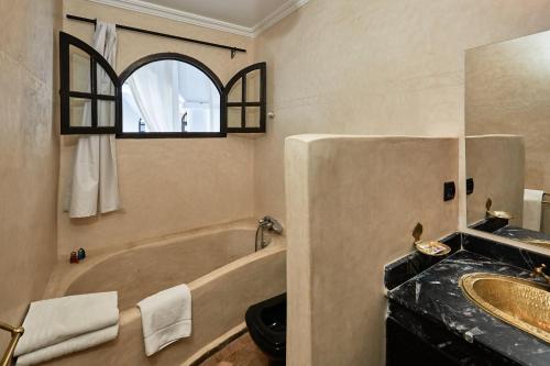 ein Badezimmer mit einer Badewanne und einem Waschbecken in der Unterkunft Riad Eldar in Marrakesch