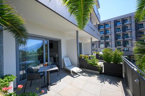 a balcony with a table and chairs and a building at Hotel Riviera in Riva del Garda