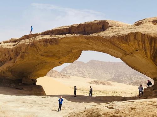 people standing in front of an arch in the desert at wadi rum land mars in Wadi Rum