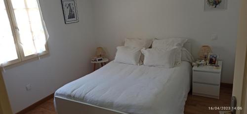 a bedroom with a white bed with white sheets and pillows at La maison de Marie in Verteuil-sur-Charente