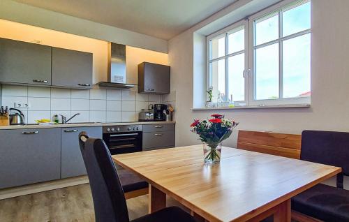 a kitchen with a wooden table with a vase of flowers on it at Ferienhaus in Zirtow bei Wesenberg in Wesenberg
