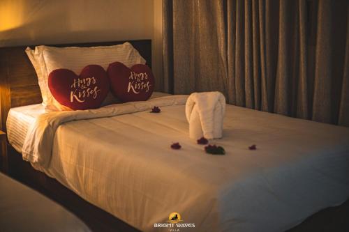 a bed with two pillows with hearts on it at Bright Waves Villa in Bentota