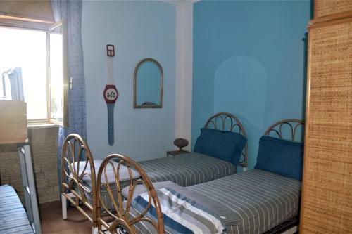 Duas camas num quarto com paredes azuis em VILLA A CAMPOMARINO em Campomarino