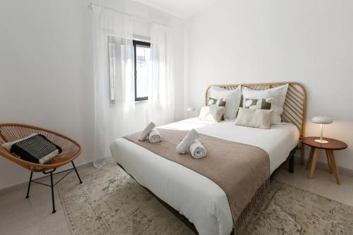 1 dormitorio blanco con 1 cama grande y 1 silla en Peniche Coastal Escape, en Peniche