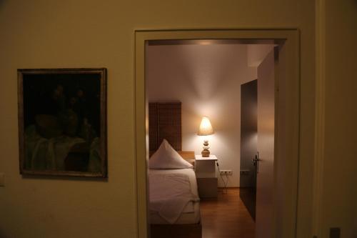 a bedroom with a bed and a lamp in a room at Hotel Löhndorf in Bonn