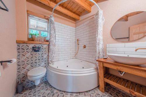 y baño con bañera, aseo y lavamanos. en Zini House en Ein Zivan